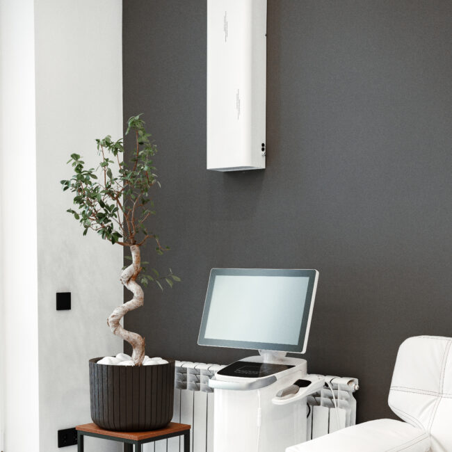 Modern medical equipment in a bright waiting area featuring a potted plant close up